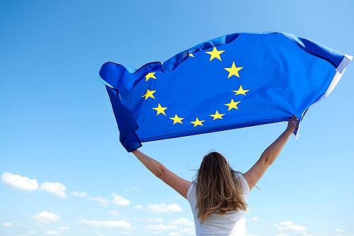 junge Frau hält Europa-Flagge hoch
